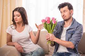 Young Man Is Offering A Bunch Of Flowers To His Angry Girlfriend At Home Stock Photo Picture And Royalty Free Image Image 37594310