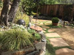 Anchored by low stone walls and four olive trees, this decomposed granite patio offers extra space to set up tables when hosting a party or can be used for a game of bocce ball. From Lawn To Beautiful Garden Finegardening