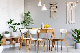 Over the bed in a bedroom, lined up with a mantel or centered in the seating area of a living room, or over a dinner table in a dining room. Macrame Hanging On Gray Wall Above Wooden Table And Chairs In Bright Dining Room Interior With Lots Of Plants Real Photo Stock Photo Picture And Royalty Free Image Image 104387484