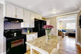 Large cottage kitchen features dark brown wooden kitchen island topped with gray granite, gray stripe counter stools, illuminated by oil rubbed bronze vintage barn lanterns and white shaker kitchen cabinets with black pulls. White Kitchen Cabinets With Black Appliances Kitchen Island Stock Photo Picture And Royalty Free Image Image 32040818