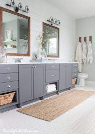 White countertops, white cabinets, wood flooring and white white bathroom countertops and pale grey cabinets for a modern bath space. Lake House Master Bath Makeover Bathroom Vanity Remodel Bathroom Remodel Master Bath Makeover