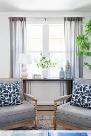 The window offers a nice frame for your sofa, without the furniture setup feeling cramped, and makes a pretty backdrop for this main piece of living room furniture. Beige Abacus Spindle Chairs With Charcoal Gray Upholstered Cushions In A Living Room In Front Of Table Decor Living Room Console Table Decorating Spindle Chair