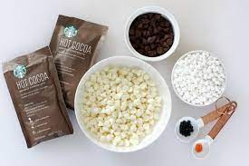 Bowl Of White Chocolate Chips Next To Bowls Of Chocolate Chips And Mini Marshmallows And Cocoa Mix Diy Hot Chocolate Chocolate Bomb Hot Chocolate Recipes