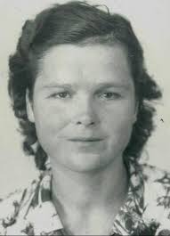 My mawmaw is in the middle. She was born 1900 . Had 7 children. The photo  is black and white but her hair was fire engine red