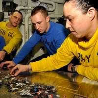 Aviation Boatswain's Mate (Equipment) Airman Joe Villanueva and Aviation  Boatswain's Mate (Equipment) 3rd Class Carl Milana clear the launching area  as a fixed wing aircraft prepares to launch.