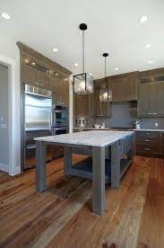 The grey of this kitchen island contrasts the bright white of the cupboards while the backsplash adds a bit of color to the room. Beautiful Kitchen With Soft Gray Walls Paint Color Trim Ceiling Painted Benjamin Moore Grey Kitchen Designs White Granite Countertops Gray Stained Cabinets