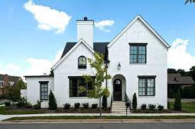 Any areas of brick that receive limited sunlight exposure may be susceptible to moss, mold or mildew growth, which will appear as green or black patches on the walls. White Painted Brick House Black Exterior Window Trim Exterior Traditional With White Brick Siding P White Brick Houses House Paint Exterior Painted Brick House