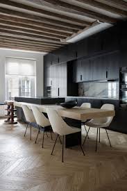 Because a brightly painted ceiling can make your home feel like a hospital, painting those exposed beams in black will create a bohemian look. A Matte Black Kitchen Contrasts The Lighter Interior Furnishings Inside This Apartment