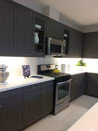 Stainless steel appliances with its durable, supreme qualities and trendy designs are easily integrated into this kitchen style. Dark Brown Black Kitchen Cabinets Light Quartz Countertop White Backsplash L Backsplash For White Cabinets Backsplash With Dark Cabinets Dark Countertops