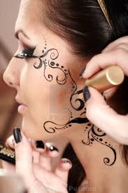 brunette having applied face tattoo by