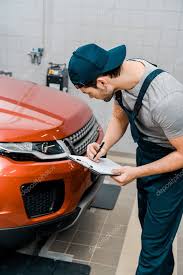 young auto mechanic uniform notepad examining car auto repair shop stock picture sponsored uniform notepad m auto repair car mechanic auto repair shop