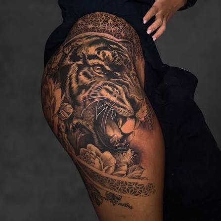 Power, beauty, and attitude all in one piece 🐯🌿 This black & grey tiger thigh tattoo is packed with energy — bold roar, clean whisker details, smooth shading, and floral elements to