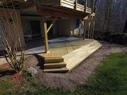 Under Deck Patio With Pressure Treated Pine Landing And Stairs Is Protected From Rain With Timbertech Dryspac Concrete Patio Cost Patio Pictures Concrete Patio