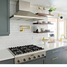 Modern Kitchen With Grey Cabinets White Subway Tile Brass Accents And Natural Wood Floating Shelves New Kitchen Cabinets Modern Kitchen Kitchen Renovation