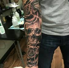 Couples can try matching skull candy tattoos and a cool idea would be to tie up two skulls along with pretty flowers just like this. A Very Charming Skull Skull Sleeve Tattoos Skull Rose Tattoos Skull Sleeve