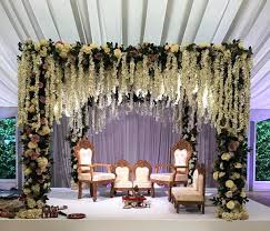 Bridesmaids in magenta saris, bride with a white bouquet. 27 Latest Floral Mandap Designs For An Enchanting Wedding Decor Shaadisaga