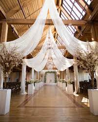 Our Favorite Ways To Decorate Your Wedding Venue With Chandeliers Wedding Ceiling Rustic Glam Wedding Wedding Venues Indoor