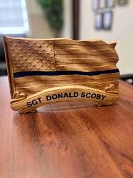 Artists gift plaques to honor fallen Sgt. Donald Scoby; radio call number  retired by department in remembrance
