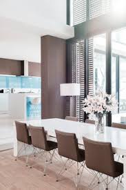 If you want to have a unique dining room, then white should be your choice. View Of Modern Dining Room With White Lilies In Vase On Table Stockphoto