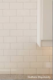 Installing a gray subway tile in this kitchen backsplash and grouting it with white grout. White Subway Tile Backsplash With Gray Grout