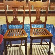 Two hand crafted oak wooden garden chairs standing on a terracotta tiled patio, with plants and trees to the rear. A Pair Of Old Oak Chairs Sentimental About Wood