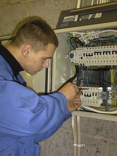 Electrician carefully wiring socket terminals with insulated screwdriver