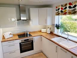 It allows greater potential for installation in one piece with no cuts, no joints and no limits. White Gloss Units Wooden Worktops Grey Tiles Kitchen Remodel Small Wood Countertops Kitchen Kitchen Design Small