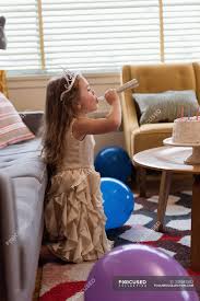Check spelling or type a new query. Cute Girl Blowing A Party Horn In Living Room At Home Smiling Authentic Stock Photo 208542502