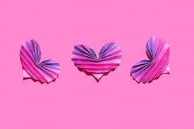 Studio Shot Of Three Pink And Purple Origami Hearts Stock Photo