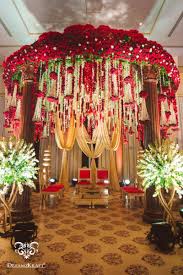 Bridesmaids in magenta saris, bride with a white bouquet. Floral Mandap Decor Indoor Floral Mandap Decor Wedmegood Wedmegood India Wedding Flower Decorations Wedding Stage Decorations Beautiful Wedding Decorations