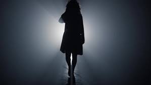 Silhouette of Woman Walking into Bright Light