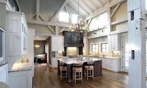 Interior White Cabinet On The Wooden Floor Pole Barn Houses Interior With Warm Chandelier Can Add The Beauty I Barn House Interior Barn Kitchen Pole Barn Homes