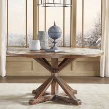 A round dining table finished in a greyed wash color with a rustic finish showing exposed saw marks and set on a bracketed country kitchen base. Rustic X Base Round Pine Wood Dining Table Handy
