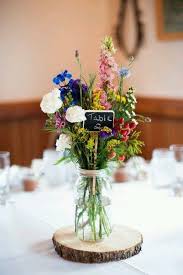 Decorating your wedding reception venue? 20 Budget Friendly Wildflower Wedding Centerpieces For Spring Summer Roses Rings Wildflower Wedding Wedding Flowers Wildflower Centerpieces