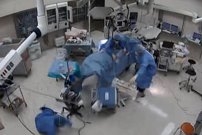 Surgeons in a Japanese hospital attempt to stabilize a patient while the room shakes violently during a major earthquake.