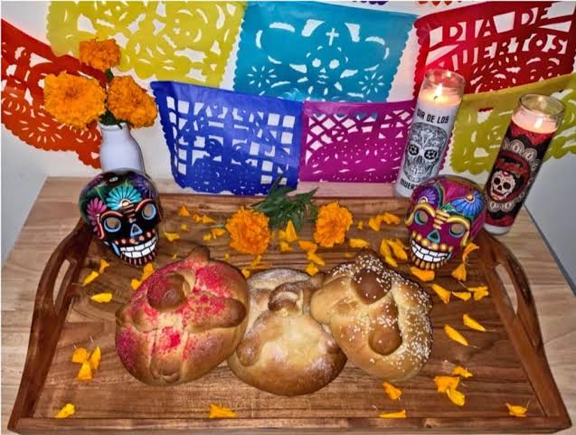 Pan de Muerto resting on a traditional Día de los Muertos altar.