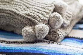 mexicaans vloerkleed met grof gebreide plaid met pompons kleurrijke woonaccessoires woonaccessoires vloerkleed