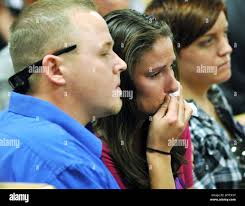 Flanked by her husband Chris Lloyd and her sister's fiancee Georgia  Lichter, the baby sister of Kristina Tournai-Sandoval, Annie Lloyd, center,  reacts after a jury found John Sandoval guilty of first degree