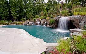 A gallery featuring both artificial and natural waterfalls attached to swimming pools. Breathtaking Pool Waterfall Design Ideas