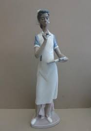 The nurse wears the trade mark llardo colors of blue and white and holds her work files under one arm. Peters Nursing Collectables Shop