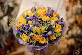 Purple and yellow flowers bouquets. Girl Holding A Bouquet With Purple And Yellow Flowers Wrapped In Violet Paper In The Blurred Background Of Flower Shop Stock Photo Picture And Royalty Free Image Image 131413692