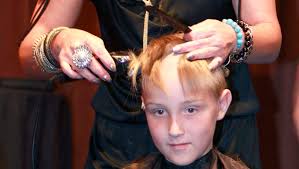 Volunteers shave their heads to show their support for cancer patients