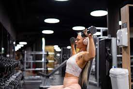 Up in the gym working on mah fitness. Young Blond Woman Working Out With Dumbbells In Gym Long Hair Sport Stock Photo 230948132