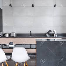 Wer holz liebt, liegt mit feinsteinzeug in holzoptik genau richtig, das gleich in mehreren kollektionen von marazzi geboten wird. Moderne Kuche Mit Schwarzen Tisch Weisse Stuhle Und Graue Fliesen Lizenzfreie Fotos Bilder Und Stock Fotografie Image 74763589
