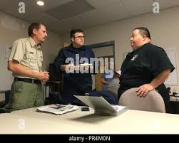 Lt. j.g. Dan Rynard, task force leader for shallow-water response assets  currently assigned to the Coast Guard's Hurricane Florence response in  North Carolina, discusses operations and field information with Shane Hardee,  Emergency