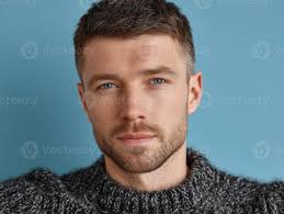 homem com curto cabelo e luz barba olhares fixos com confiança. ele  desgasta uma texturizado suéter