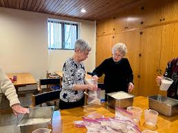 Sisters Lucy Miller, Dorothy Manuel, Judy Huber, Katherine Kraft, Katherine  Howard, Pat Ruether, Lucinda Mareck, and Laura Suhr joined Elizabeth Reum,  director of social justice ministries, to pack beans and rice, which