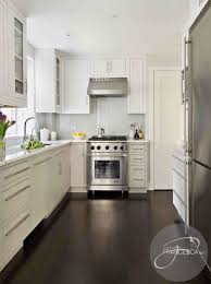 The warmth of the wood floor gives contrast to the otherwise neutral color palette. White Kitchen Cabinets Dark Hardwood Floors Contemporary Kitchen Interiors By Francesca