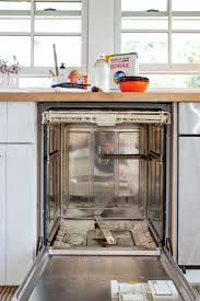 In a kitchen, white drawers with a marble countertop and white cabinets above. Domestic Science How To Clean A Dishwasher Remodelista