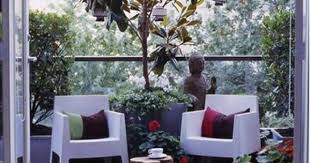 balkon deko asiatischer stil buddah statue weisse plastikstuhle tisch massivholz braune boden wohnung terrasse dekoration kleiner balkon design balkon im freien